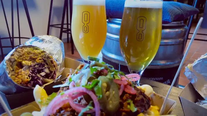 Close-up of two Ground Up beers and some tasty street food in front of them