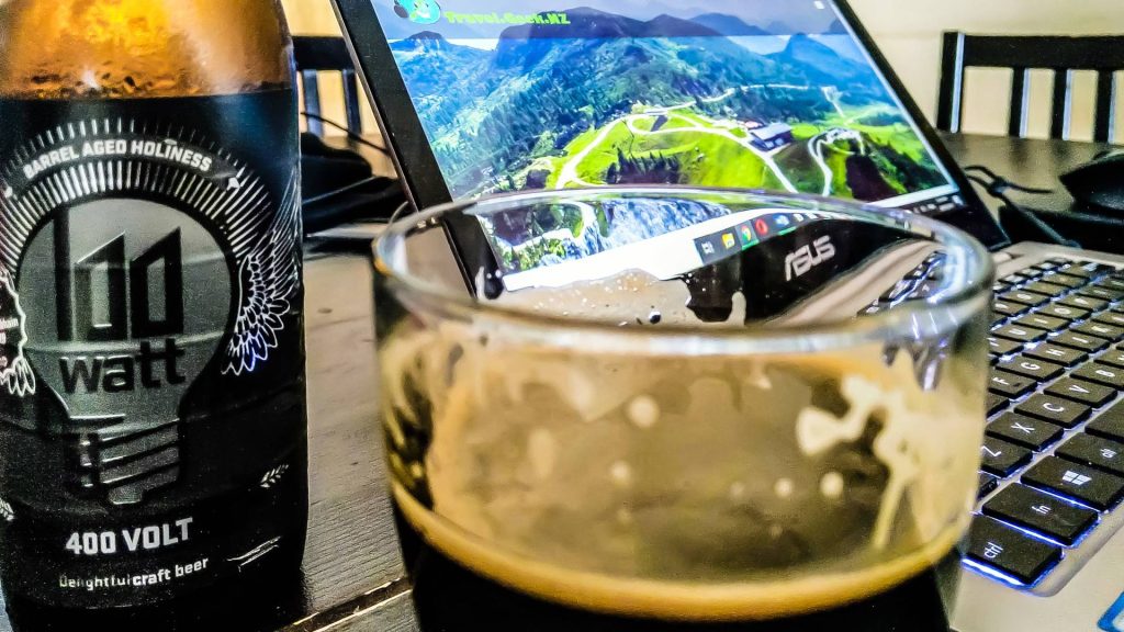 Craft beer in the front, laptop in the background. 