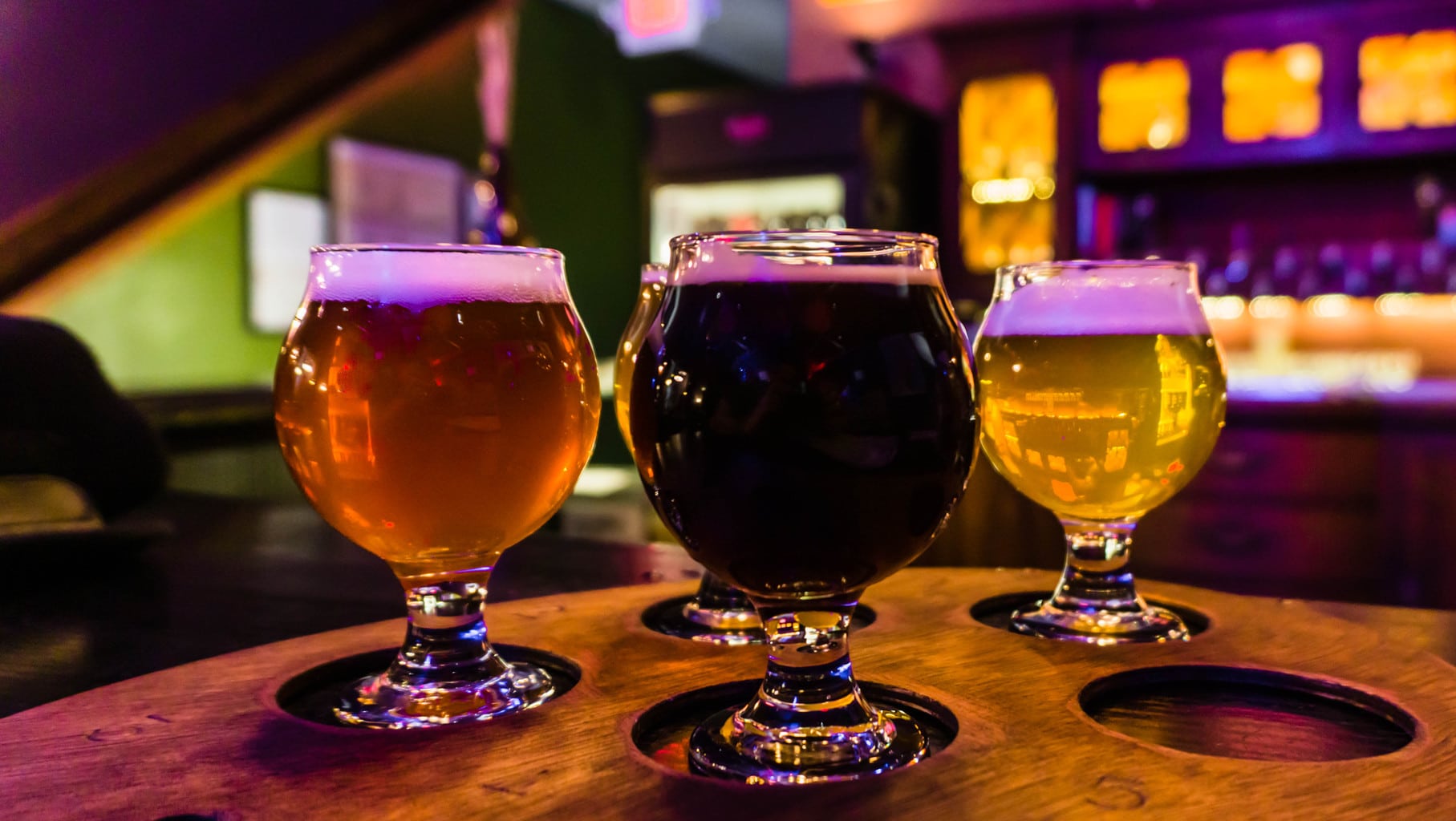 Close up of a craft beer tasting flight with a mix of dark and light coloured beers