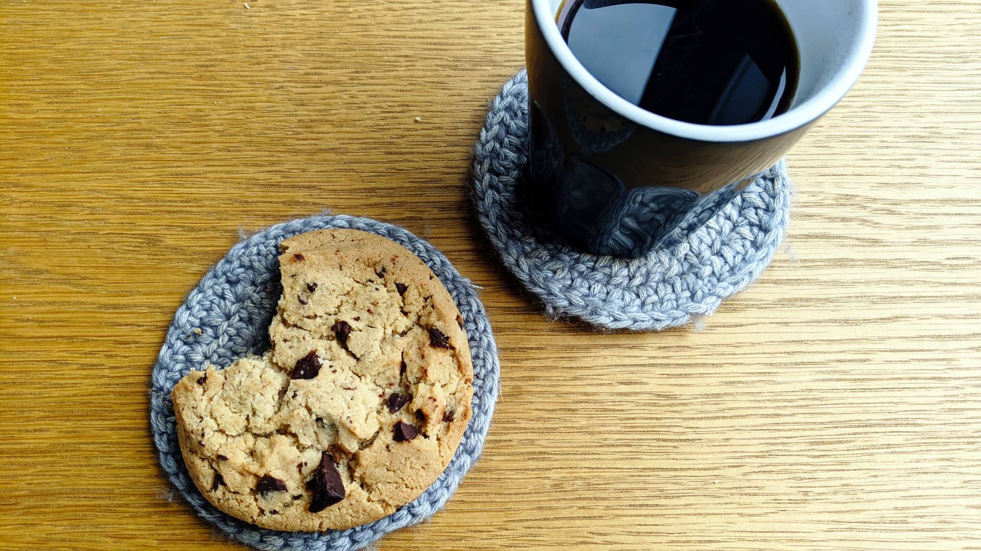 Bird's eye view of coffee mug and a cookie next to it, a big chocoloate chip cookie