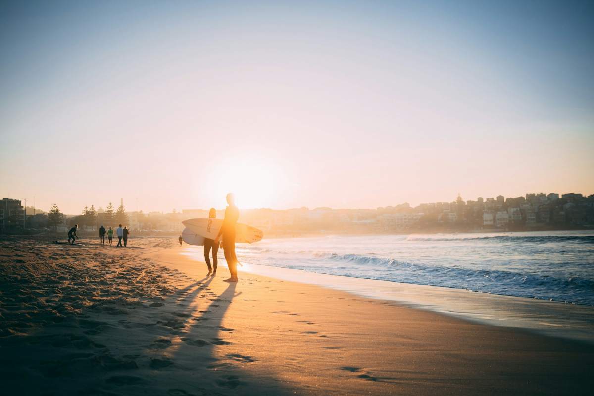 Beach photo: people holding a surfboard, ocean on the right