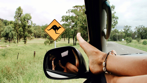 Road trip photo: passenger with feet close to open window and taking photo of the road and side mirror